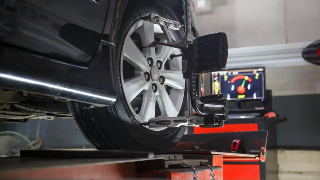 Car on stand with sensors on wheels for wheels alignment camber check in workshop of Service station.